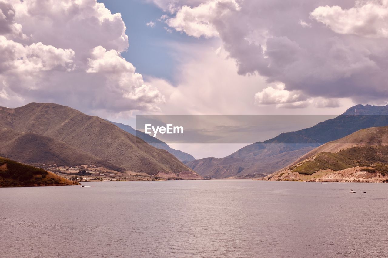 Scenic view of sea and mountains against sky