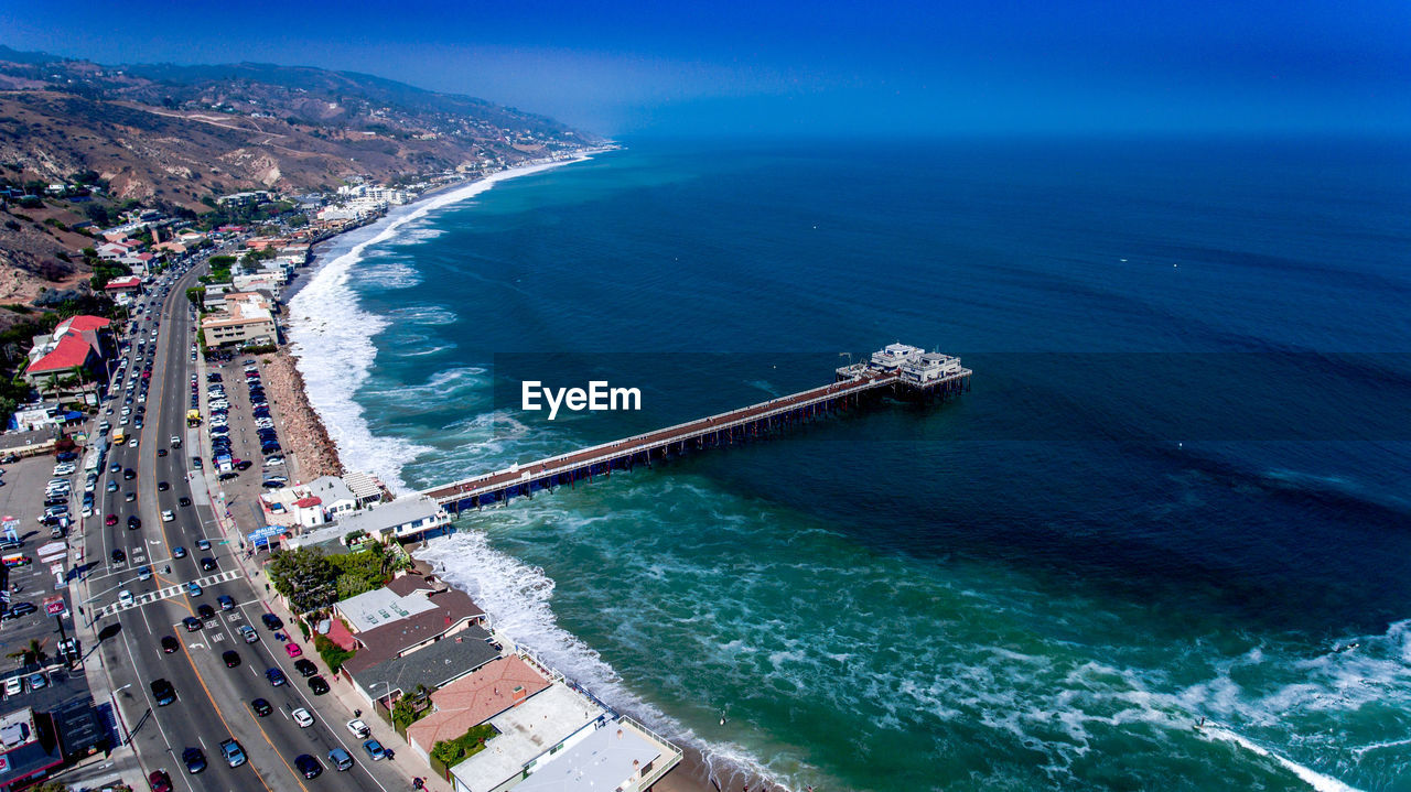 Aerial view of road beside sea