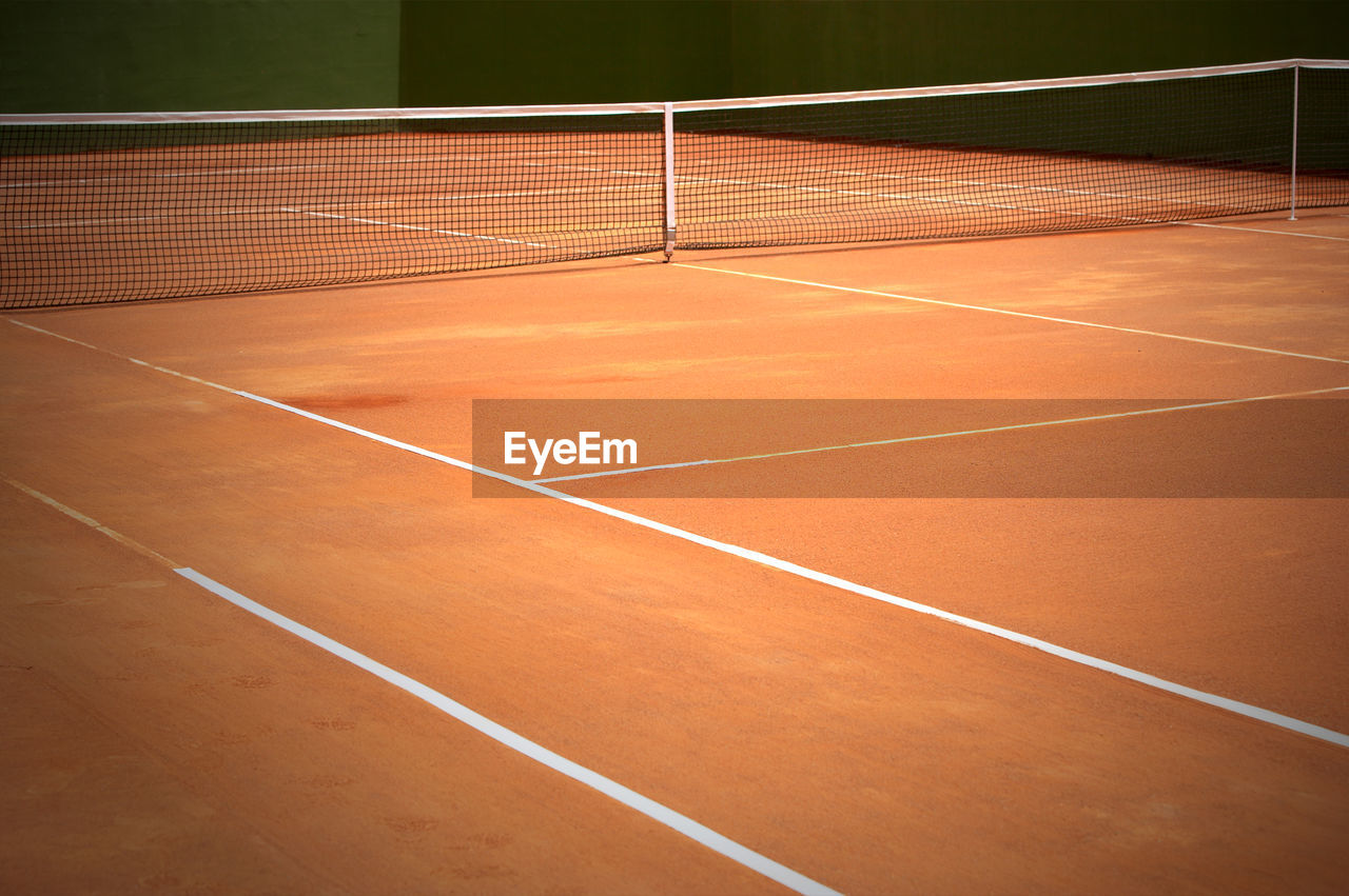 Empty tennis court during sunny day