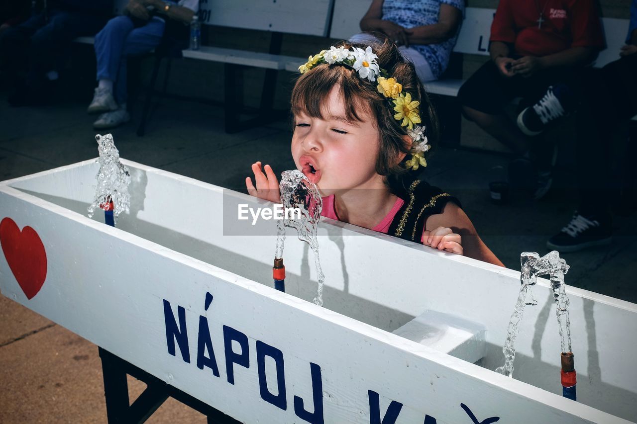 Close-up of girl drinking from fountain