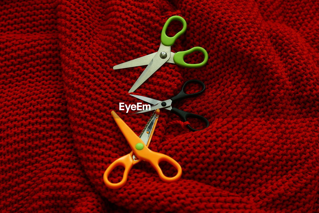 HIGH ANGLE VIEW OF RED BUTTONS ON FABRIC