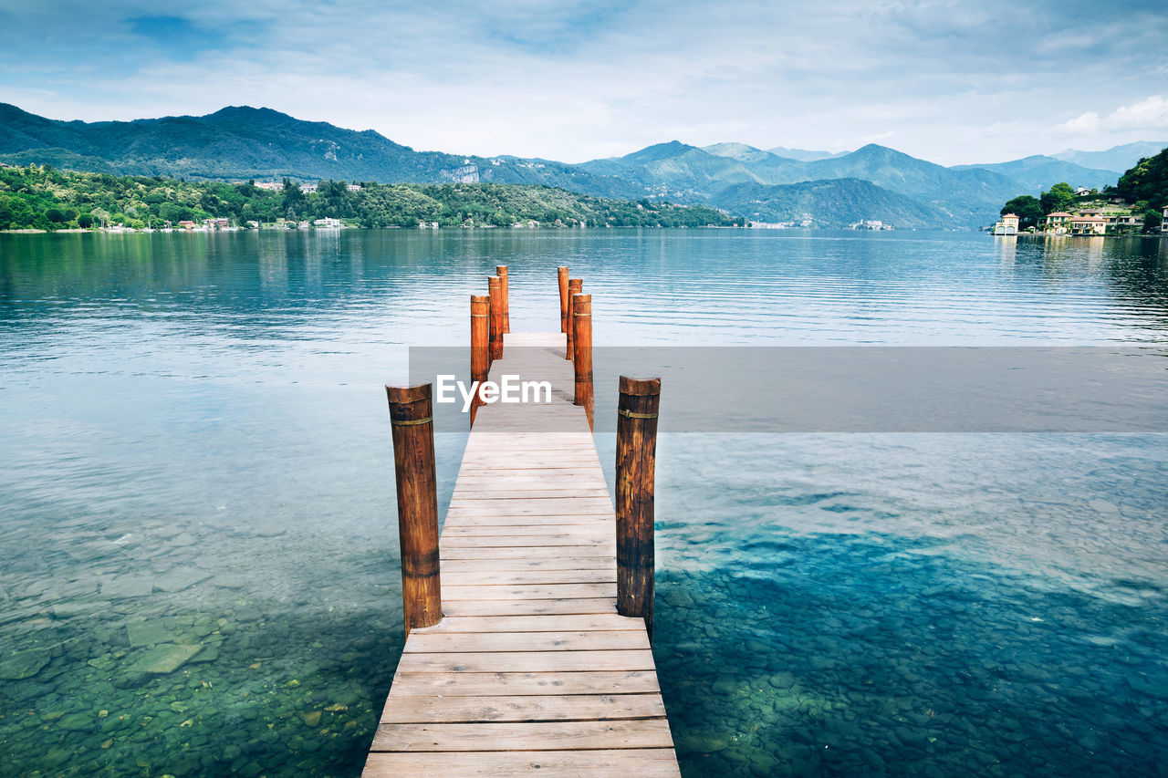 Wooden pier over lake against sky