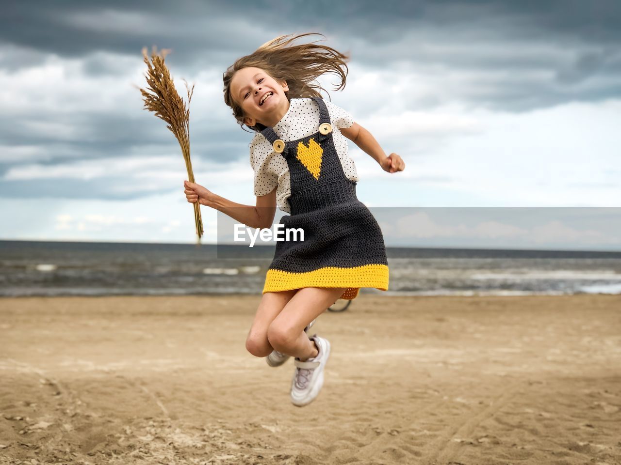 Portrait of happy girl jumping at beach