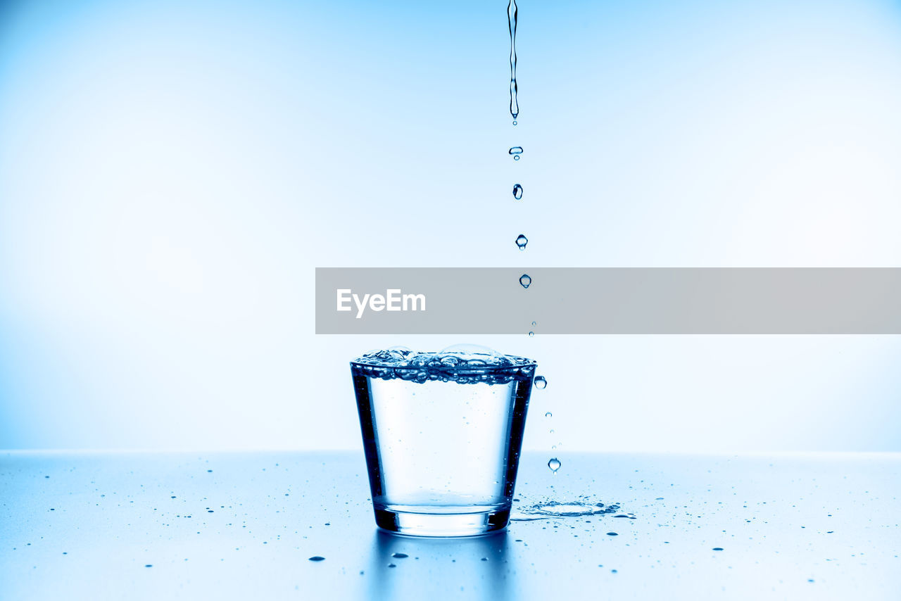 CLOSE-UP OF WATER SPLASHING ON GLASS