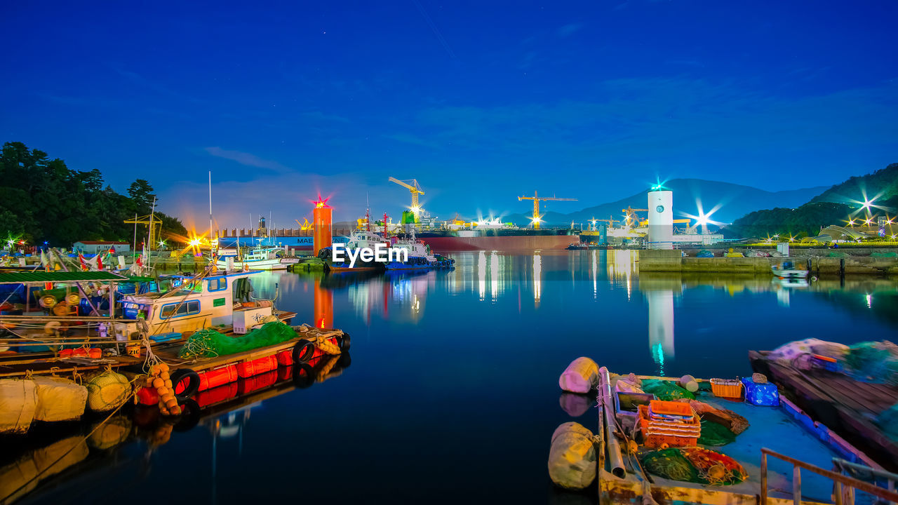 BOATS MOORED AT HARBOR AGAINST SKY