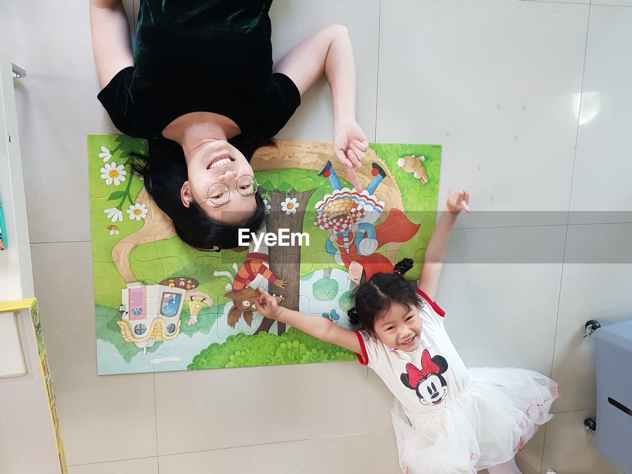 HIGH ANGLE VIEW OF MOTHER AND GIRL SITTING ON FLOOR
