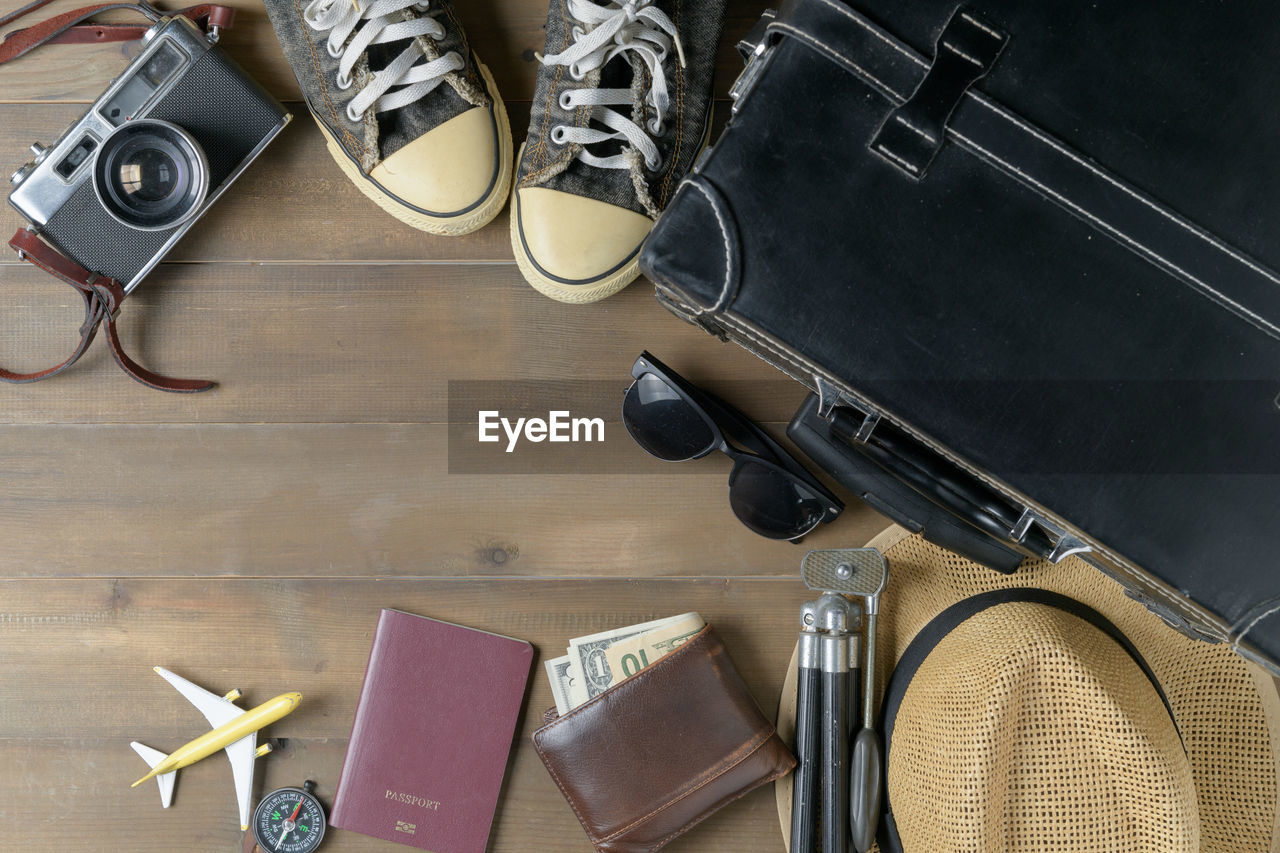 Directly above shot of travel equipment on wooden table