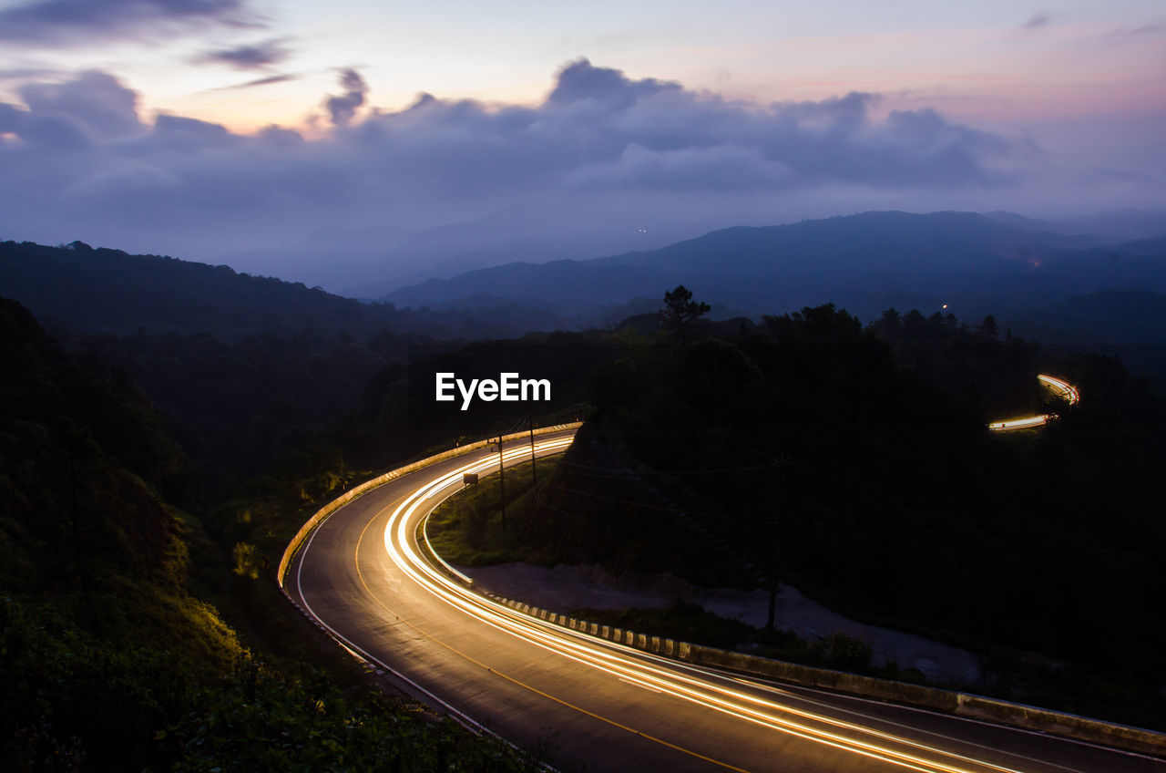 High angle view of light trails on mountain road at night