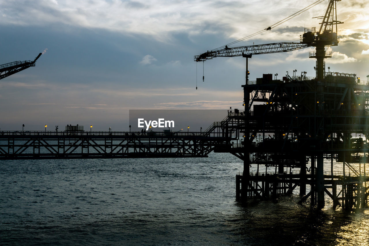 Landscape of an oil production platform during sunset