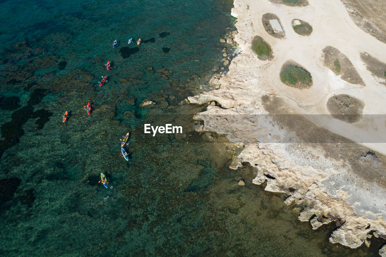 Team of people kayaking in the sea near a white rocky coastline. athletic sports in cyprus