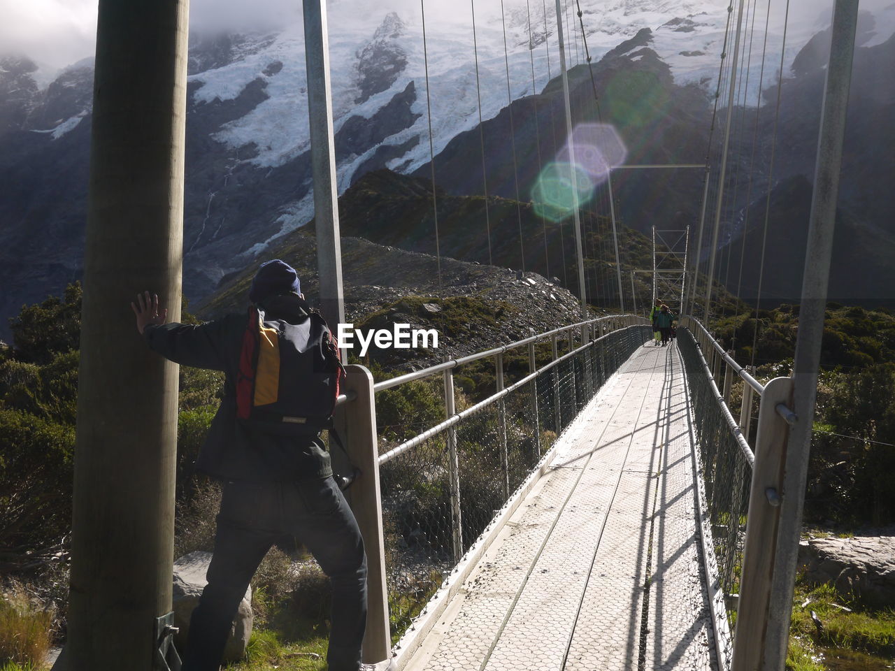 Man standing by railing against mountain