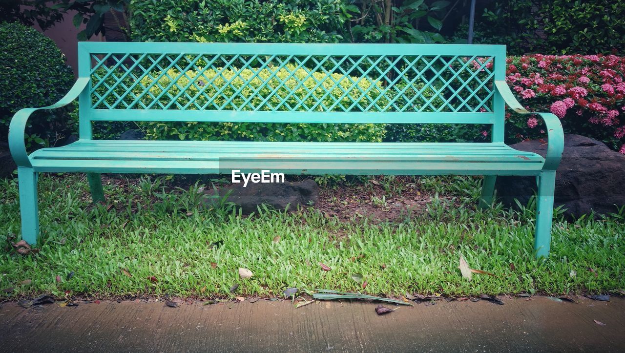 EMPTY BENCH IN PARK AT GARDEN