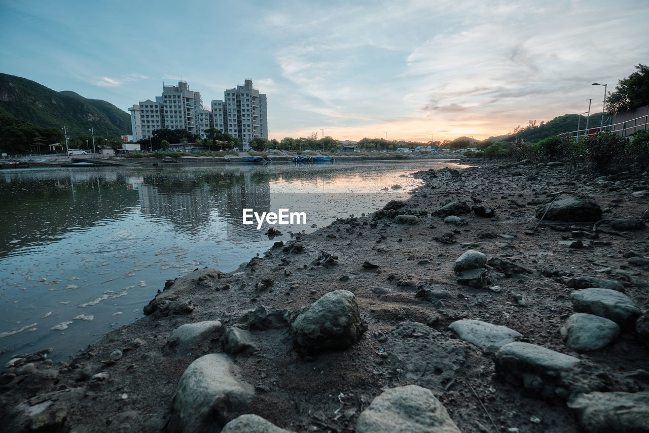 SCENIC VIEW OF RIVER AMIDST BUILDINGS AGAINST SKY