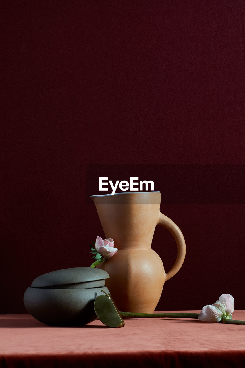 Handmade pottery and flowers on rich colored background