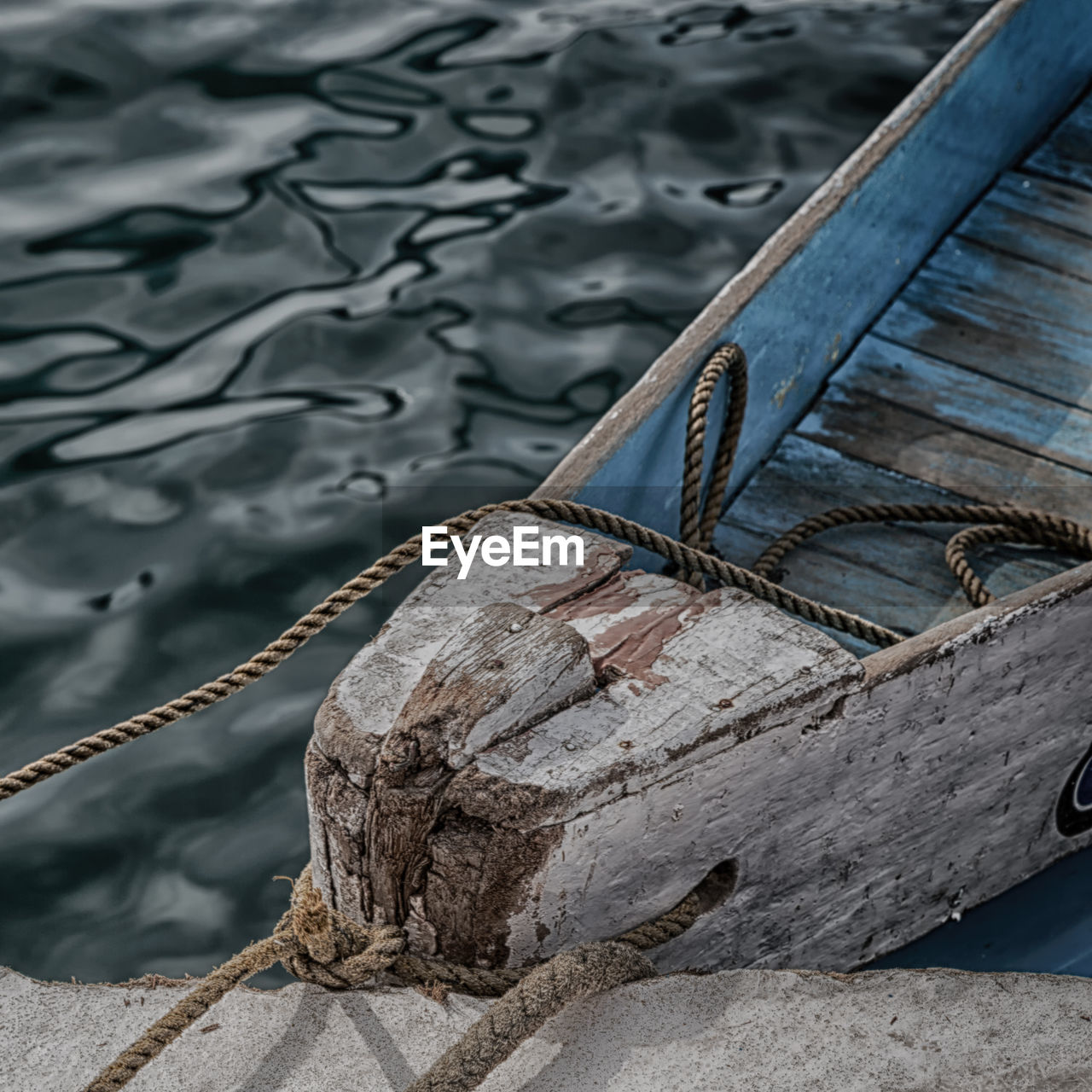 HIGH ANGLE VIEW OF ROPE TIED ON WOODEN BOAT