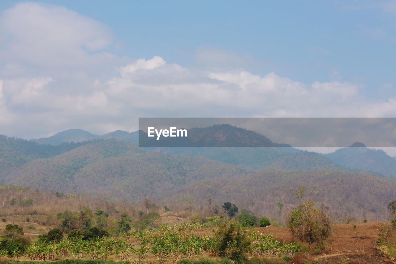 Scenic view of mountains against cloudy sky