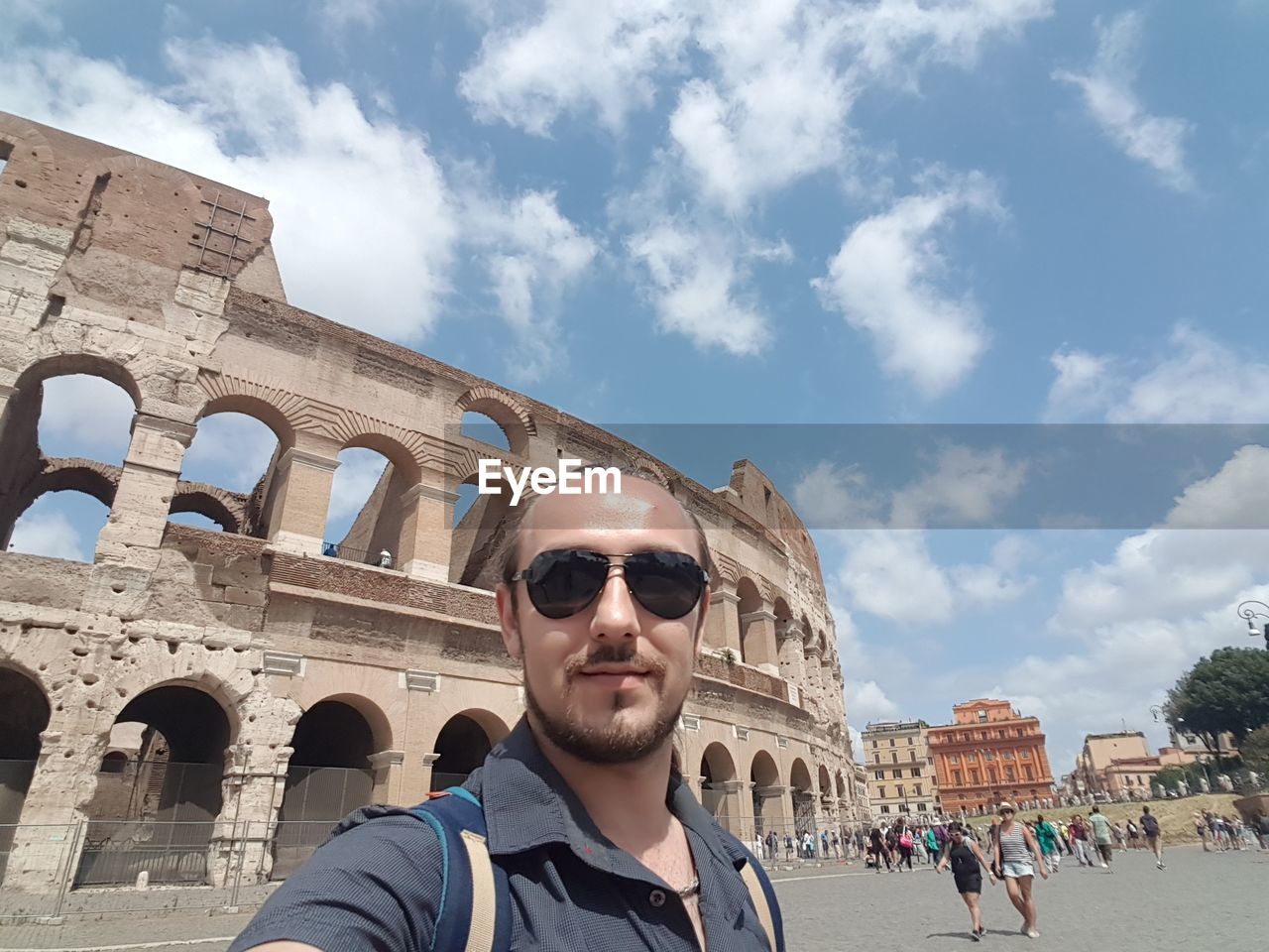 Portrait of man wearing sunglasses against coliseum