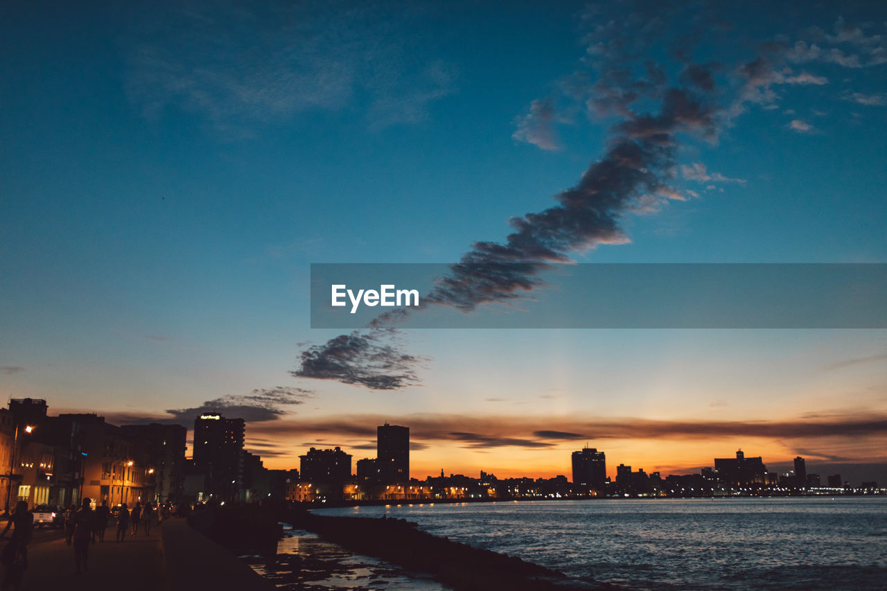 Silhouette buildings against sky at sunset