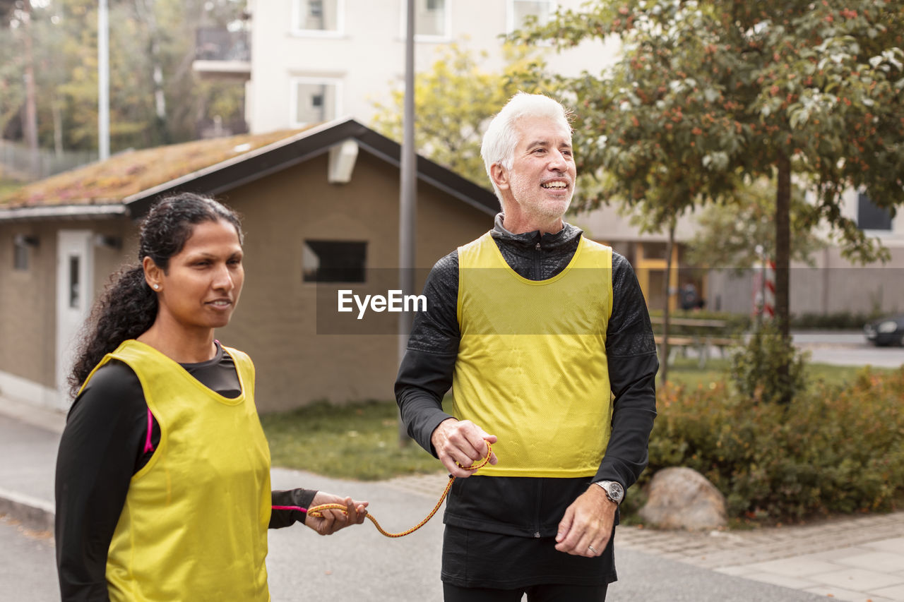 Visually impaired woman preparing for jogging with guide runner