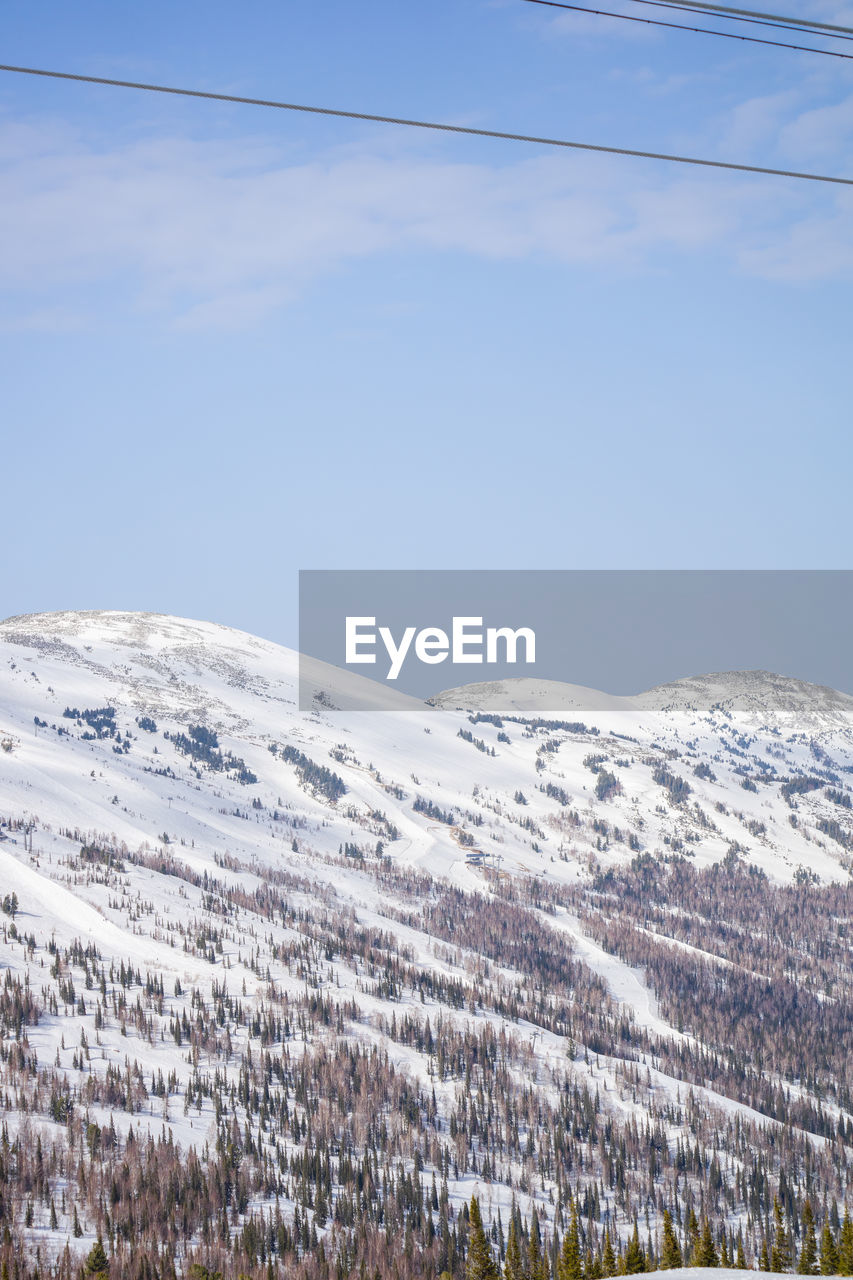 snow, winter, cold temperature, mountain, scenics - nature, beauty in nature, sky, mountain range, environment, nature, landscape, tranquil scene, no people, snowcapped mountain, day, cable, tranquility, plant, non-urban scene, land, cloud, electricity, white, outdoors, power line, idyllic, remote, tree, ridge, plateau