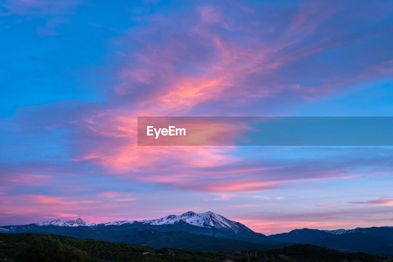 SNOWCAPPED MOUNTAINS AGAINST SKY DURING SUNSET