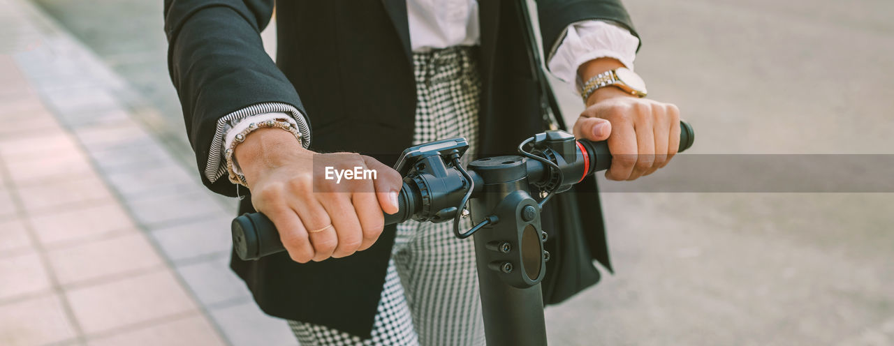 Midsection of woman riding electric push scooter