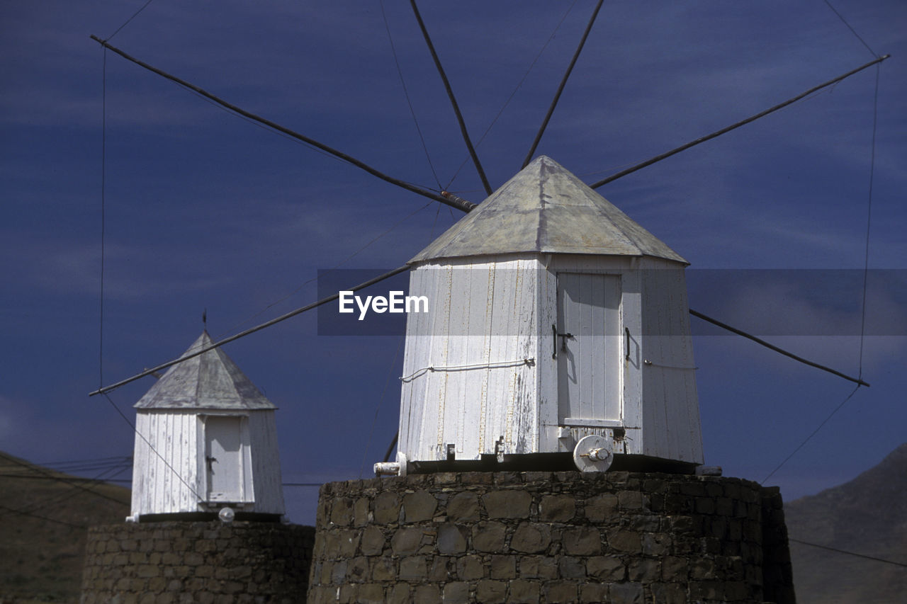 Traditional windmills against sky