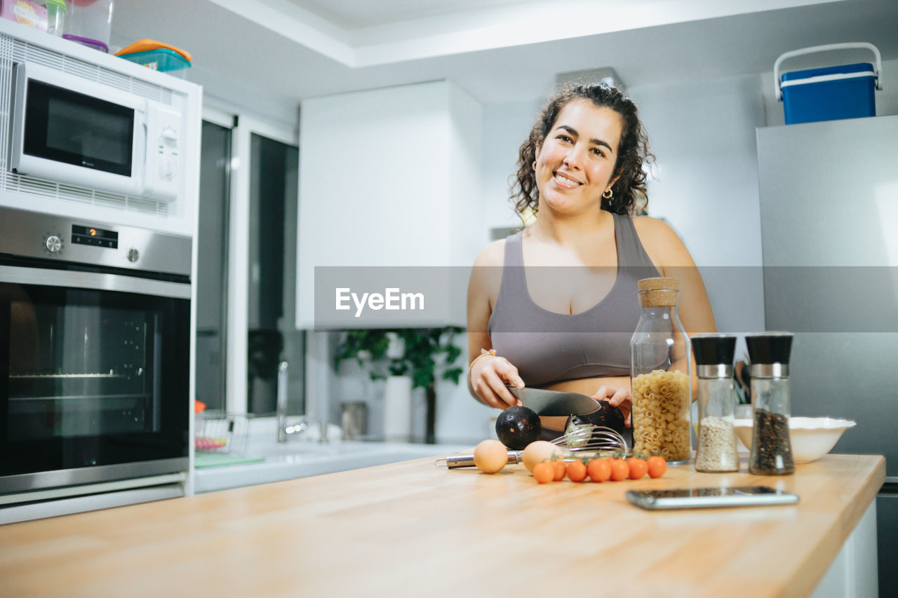 Portrait of smiling woman preparing food at home