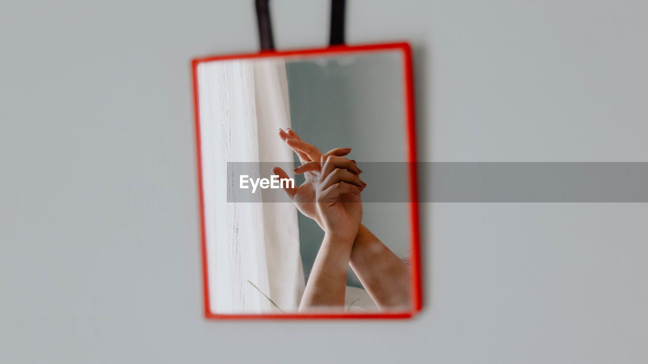 Cropped image of woman hands reflecting in mirror