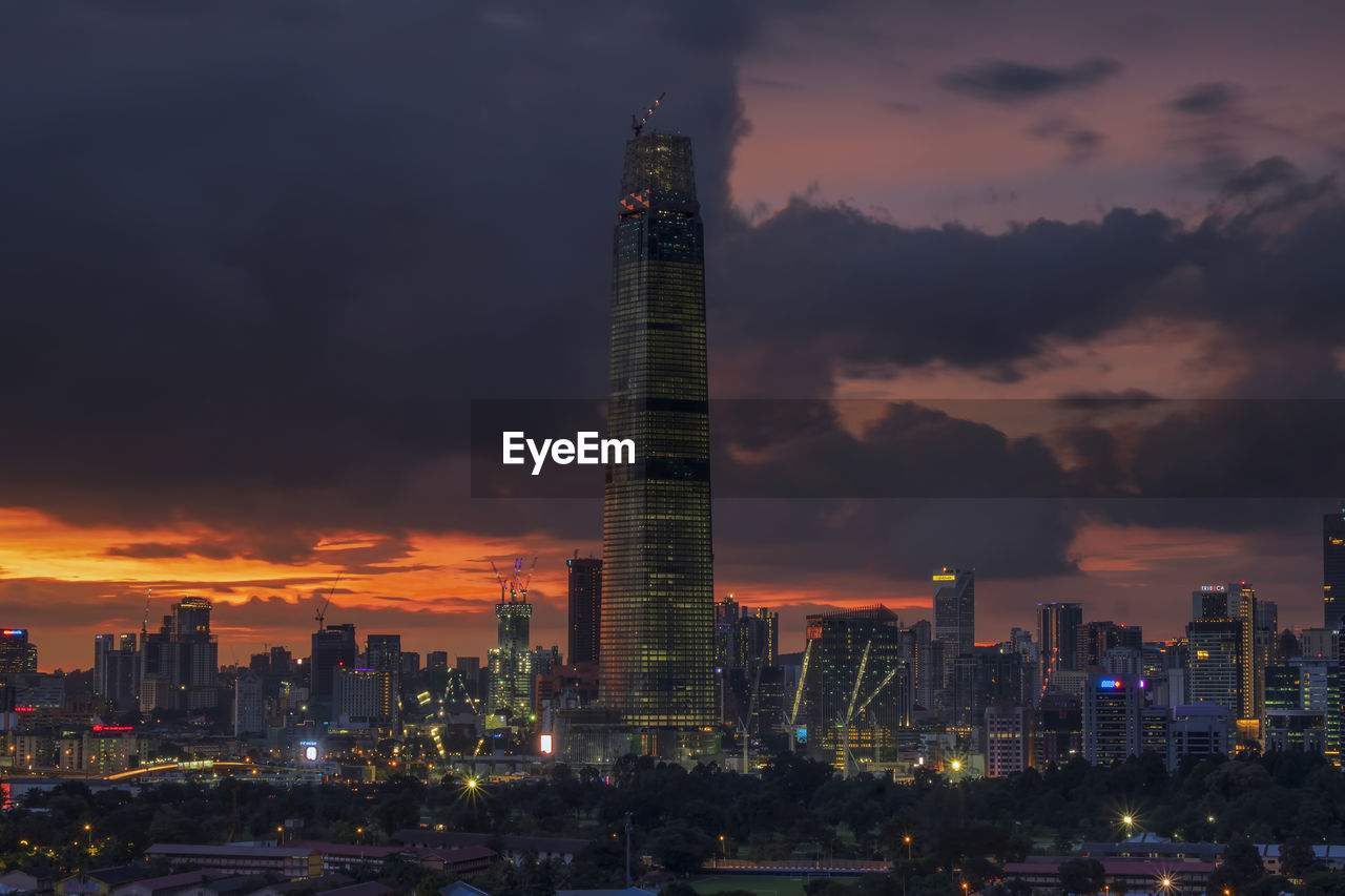 Illuminated modern buildings against sky during sunset