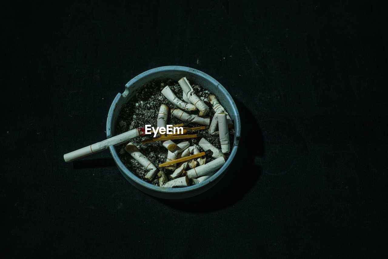 Close-up of cigarette on table against black background