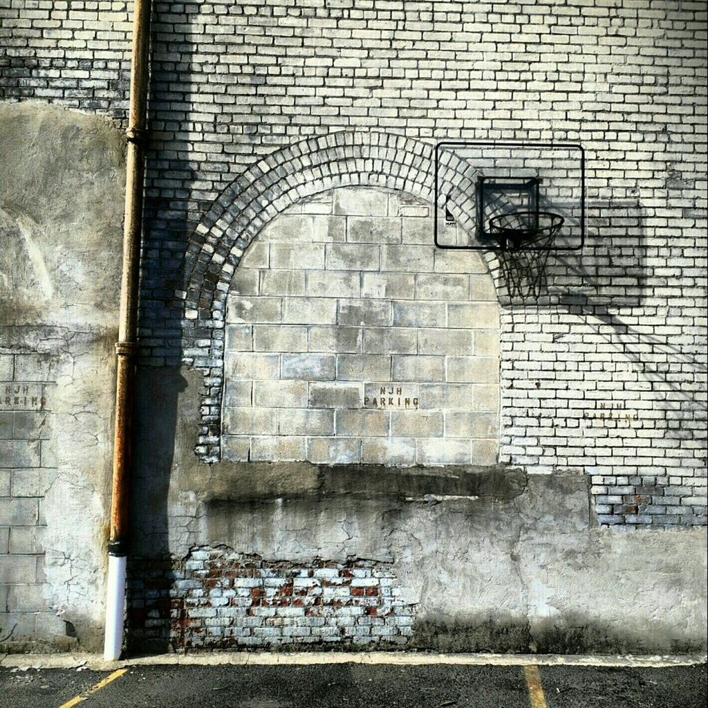 Basketball hoop on brick wall of building