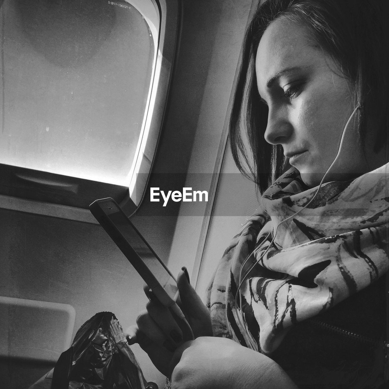 Side view of woman listening to music in train