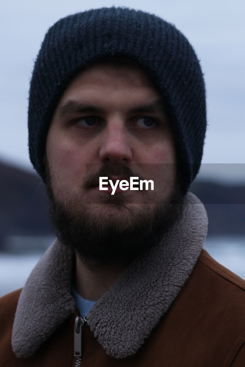 Thoughtful young man wearing warm clothing while looking away during winter