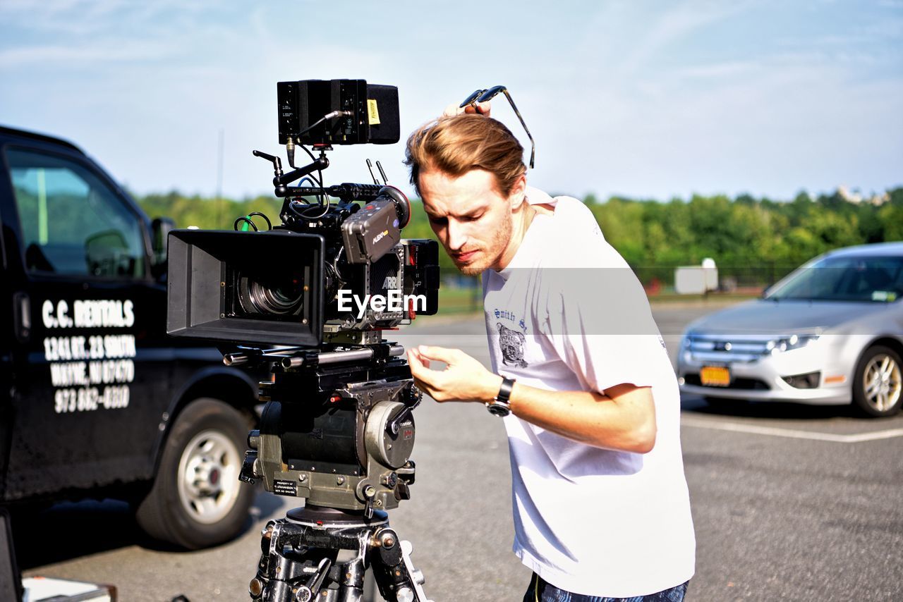 YOUNG MAN WITH CAMERA ON CITY