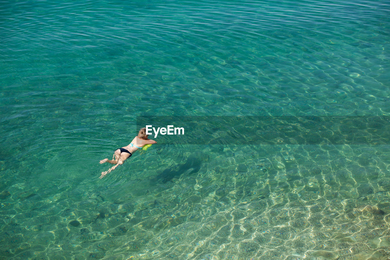 HIGH ANGLE VIEW OF WOMAN IN SEA