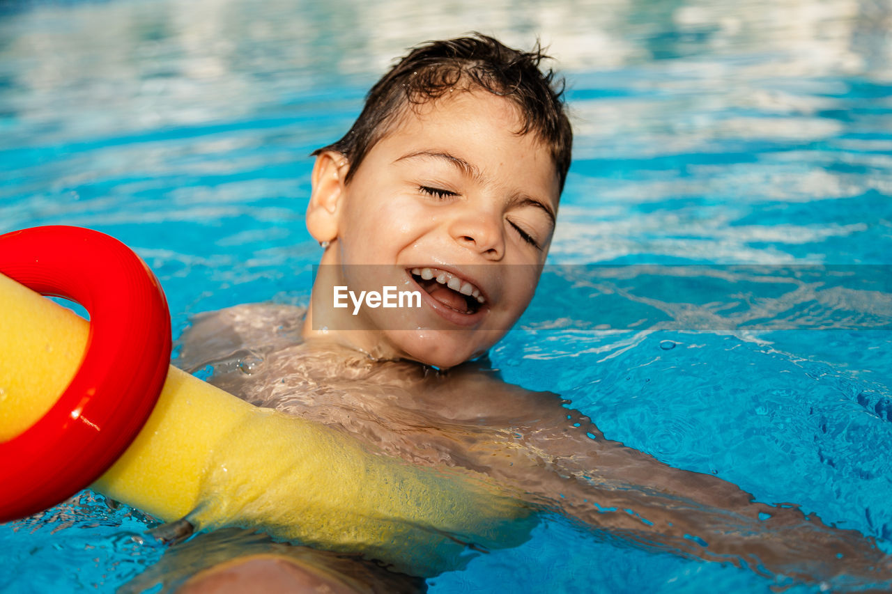 Smiling boy swimming in pool