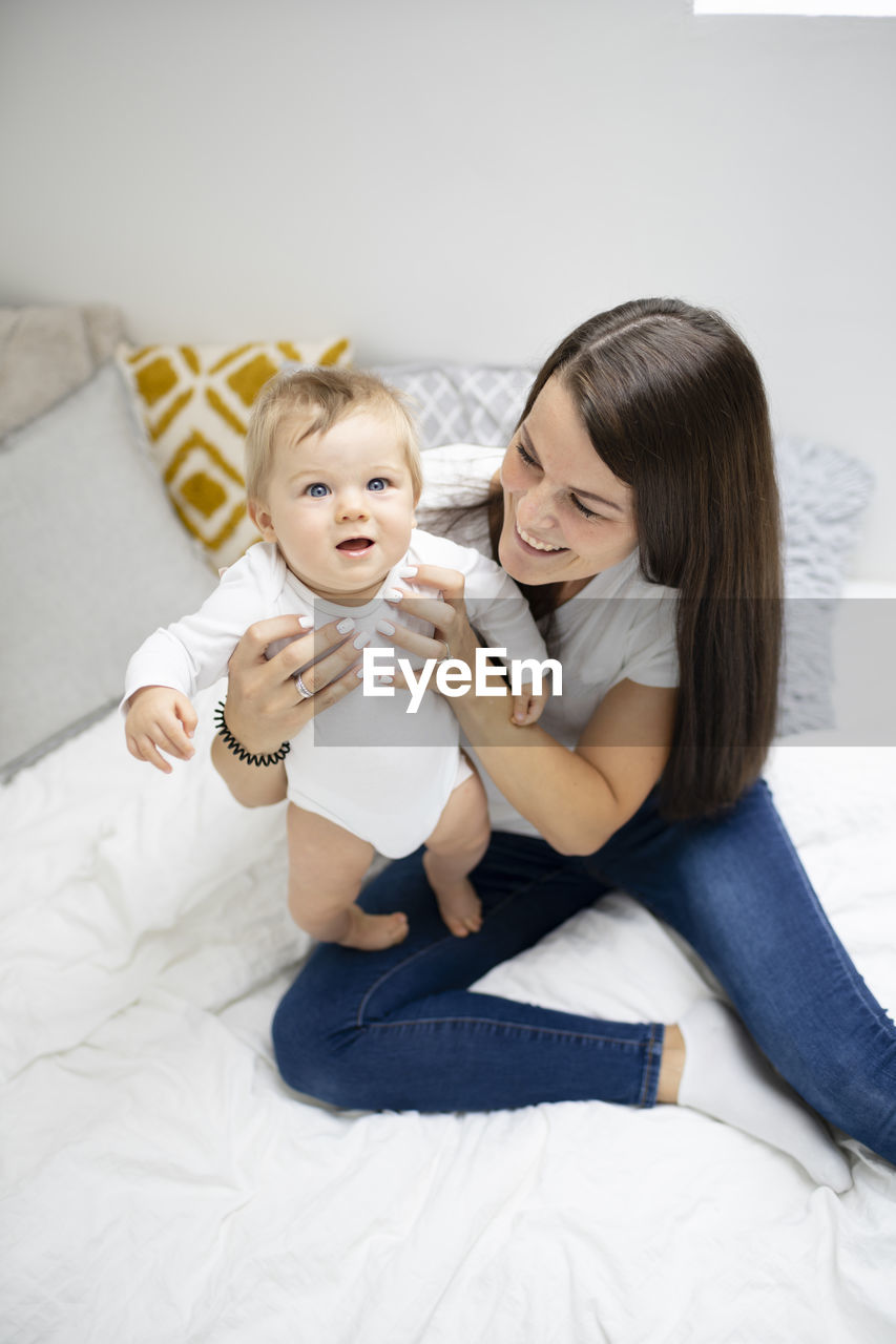 high angle view of mother and daughter lying on bed at home