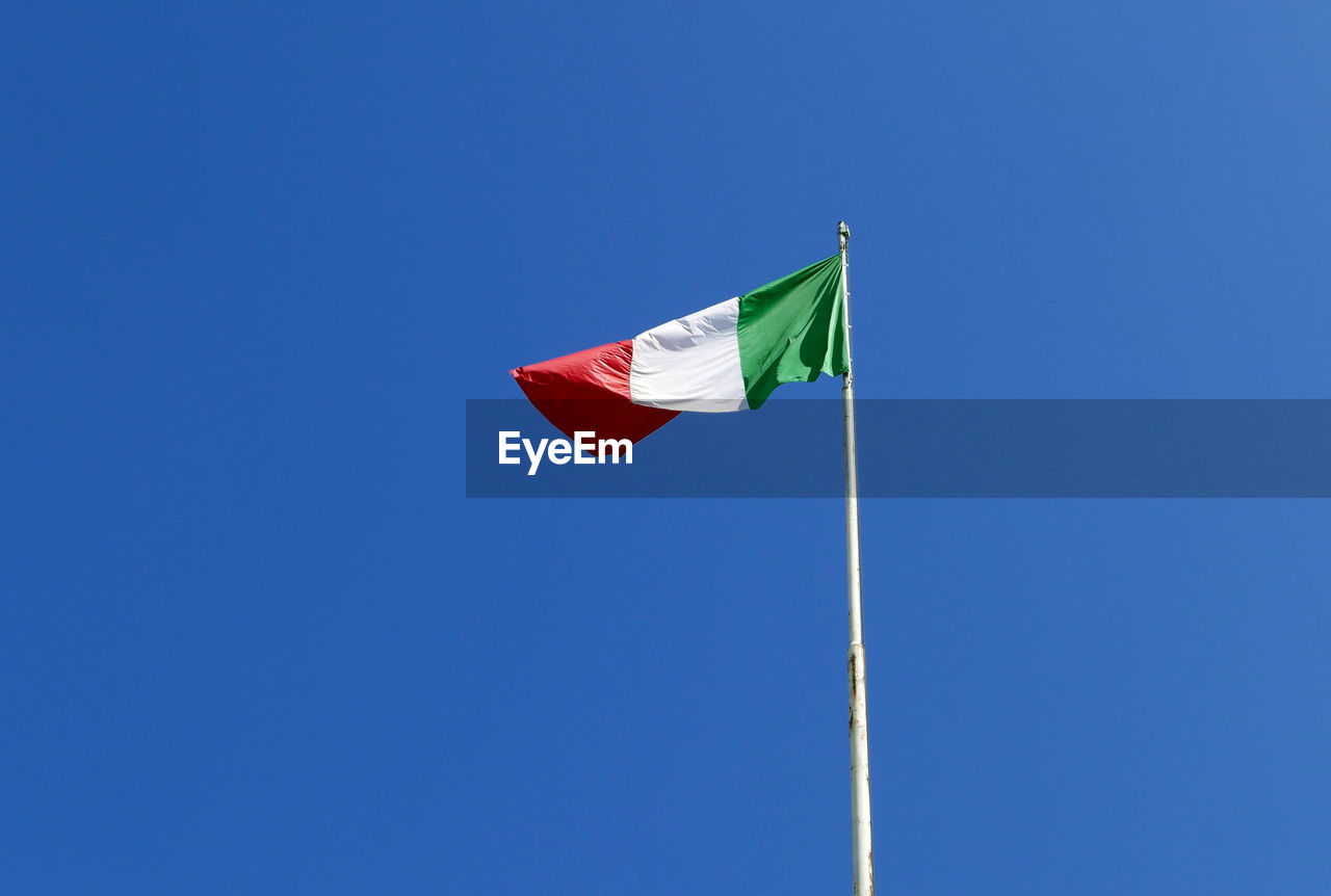 Bright and sunny italian flag waving against the blue sky