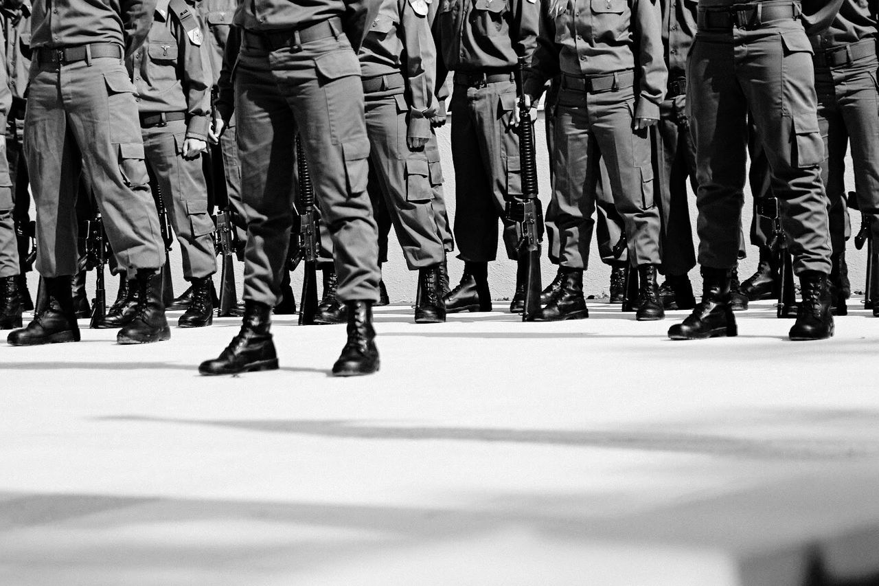 Low section of military soldiers marching on street