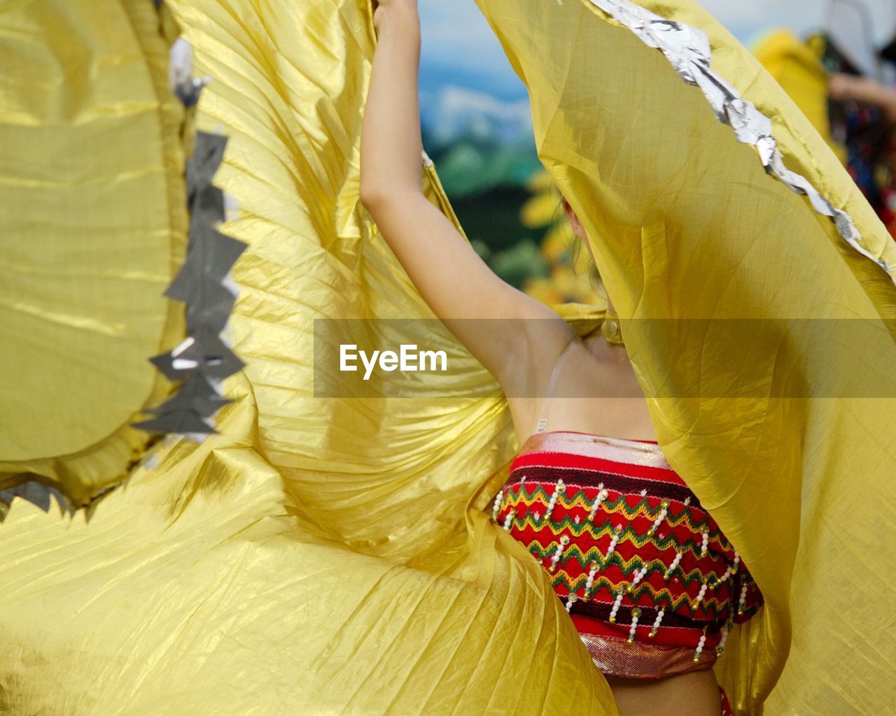 LOW SECTION OF WOMAN DANCING WITH UMBRELLAS