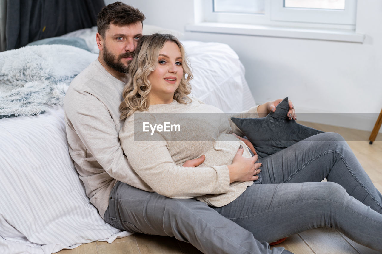 YOUNG COUPLE SITTING ON SOFA