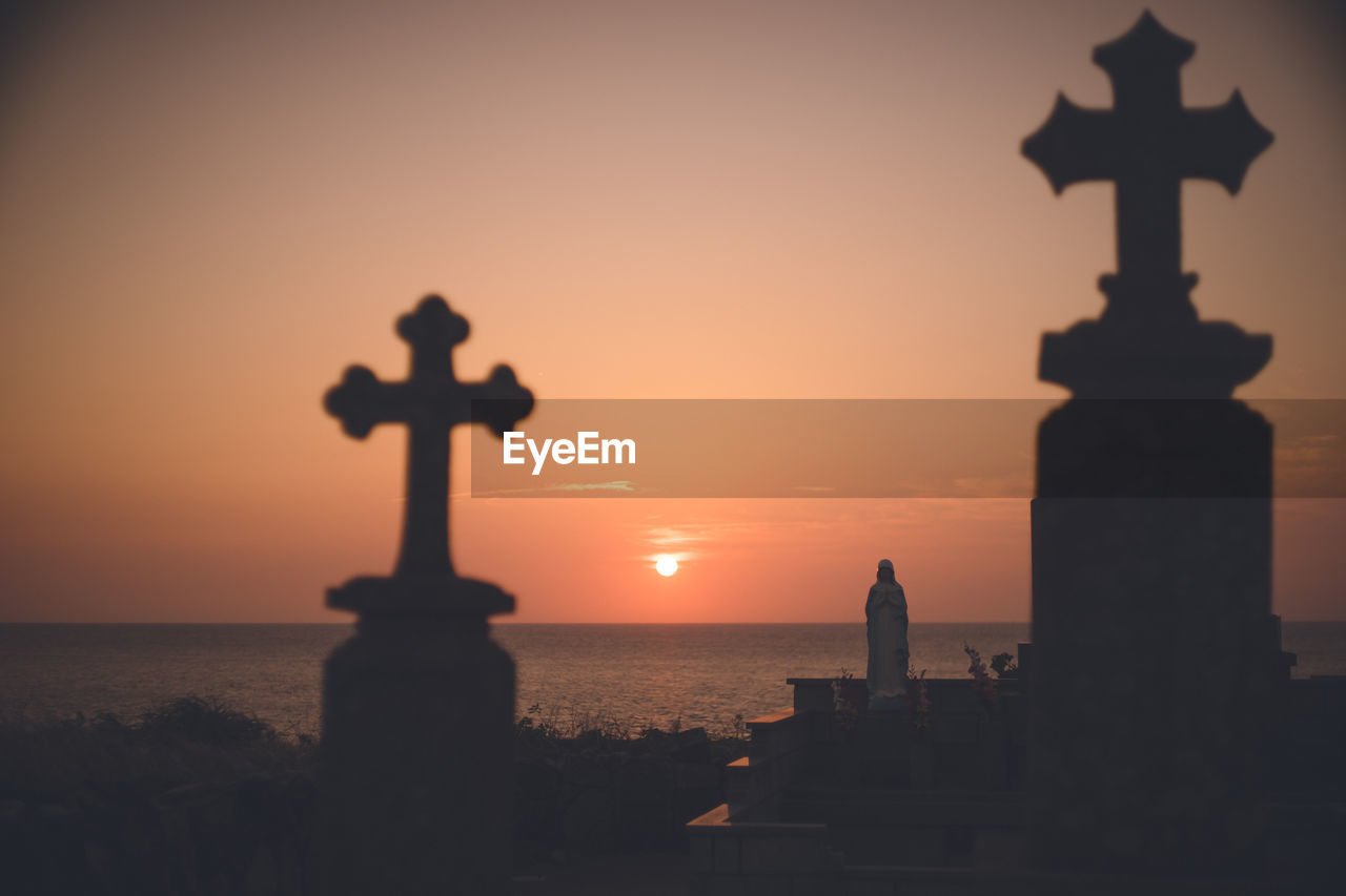 Christian cemetery and sunset over the sea tombstone built against the sea on the beach at nagasaki