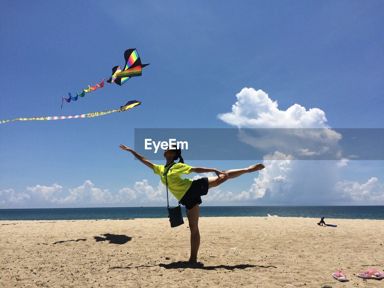 Full length of woman practicing yoga at beach during summer