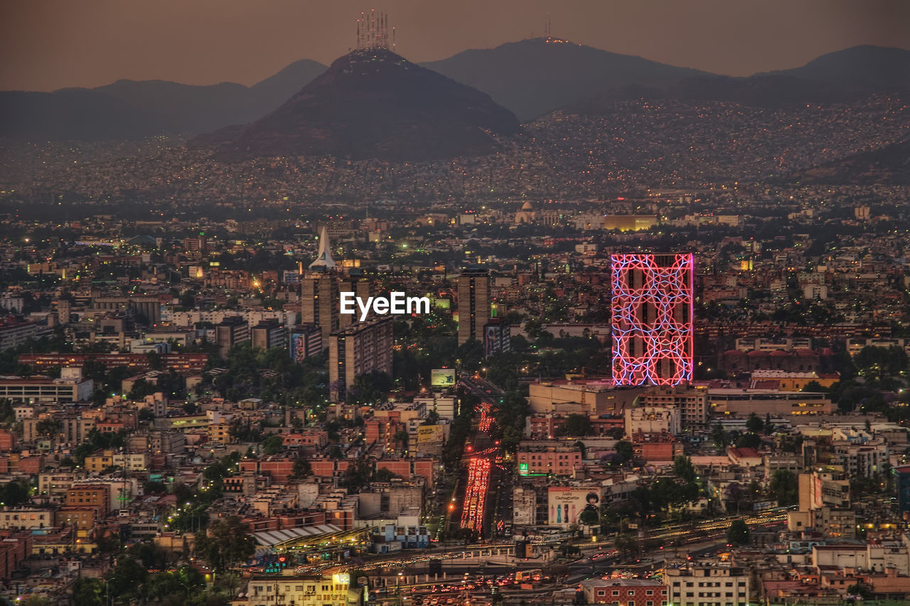 HIGH ANGLE VIEW OF ILLUMINATED CITY BUILDINGS