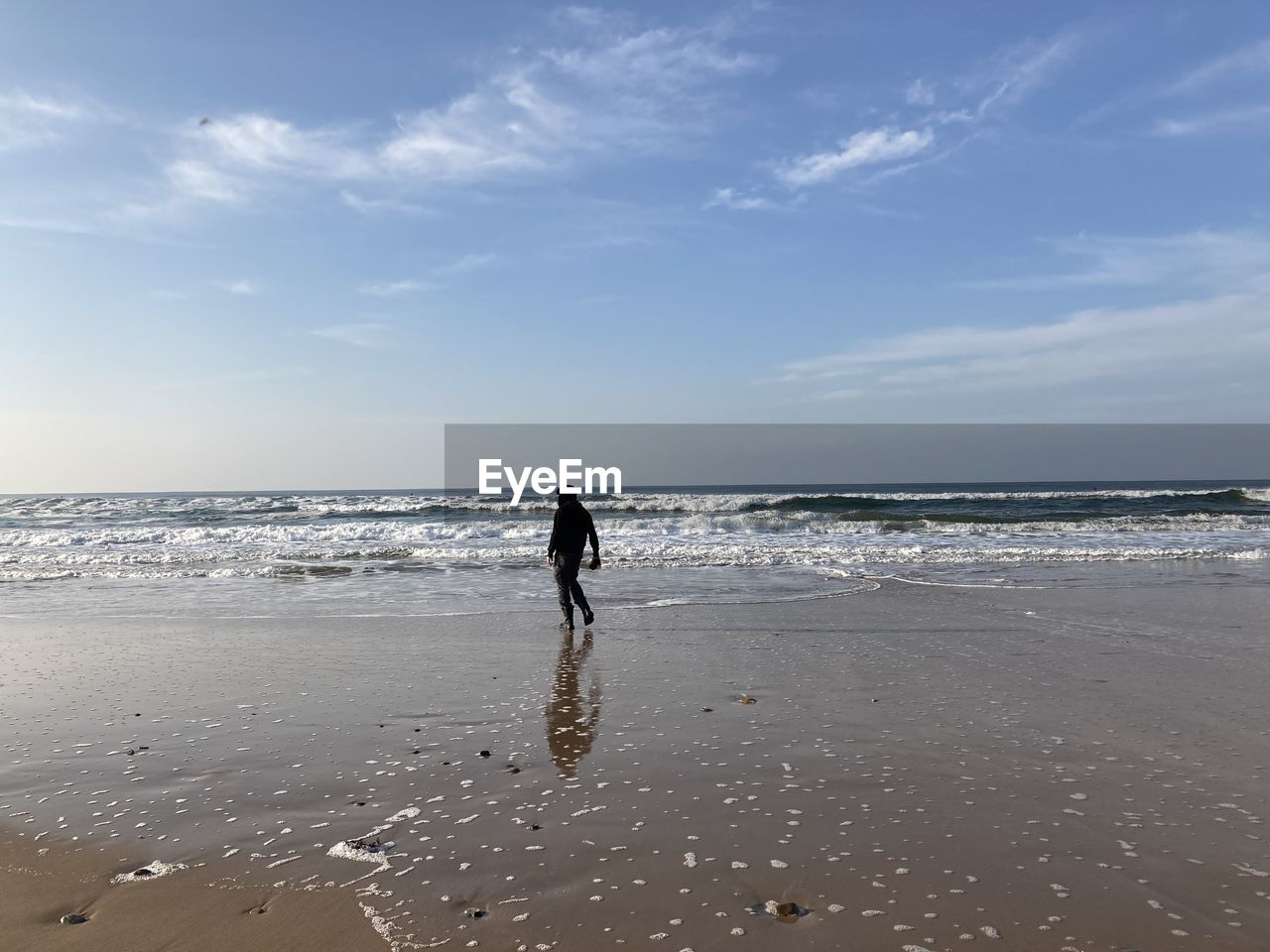 REAR VIEW OF WOMAN WALKING ON BEACH