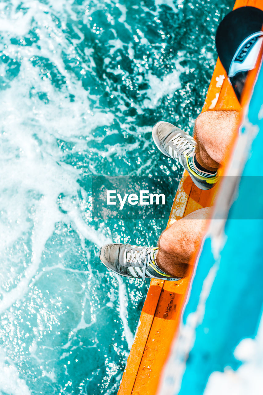 HIGH ANGLE VIEW OF MAN SWIMMING IN POOL