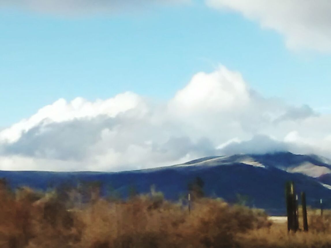 SCENIC VIEW OF MOUNTAINS AGAINST CLOUDY SKY