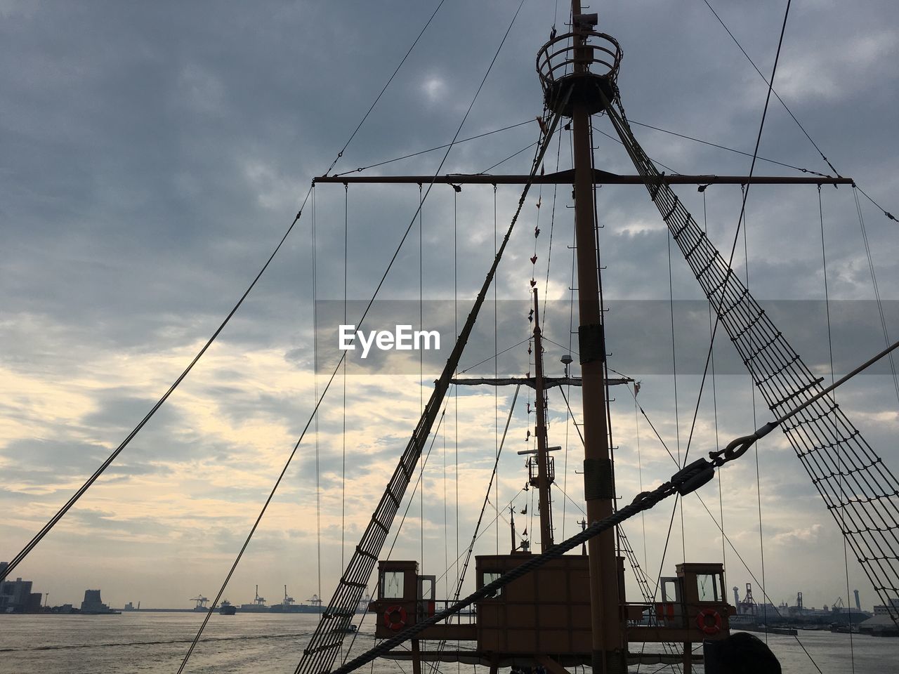 Boat on sea against cloudy sky during sunset