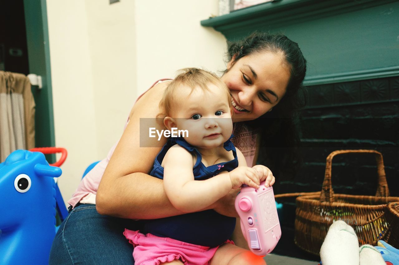 Portrait of cute daughter with mother at home